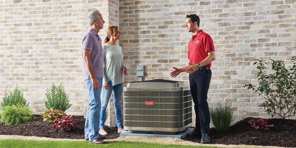 Bryant technician showing a couple a newly installed air conditioner