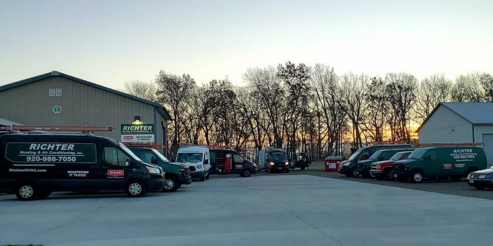 Richter building and parking lot filled with work vans loading supplies for the work day
